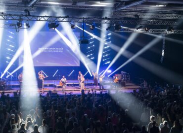 Band und Publikum werden beim Konzert angestrahlt.